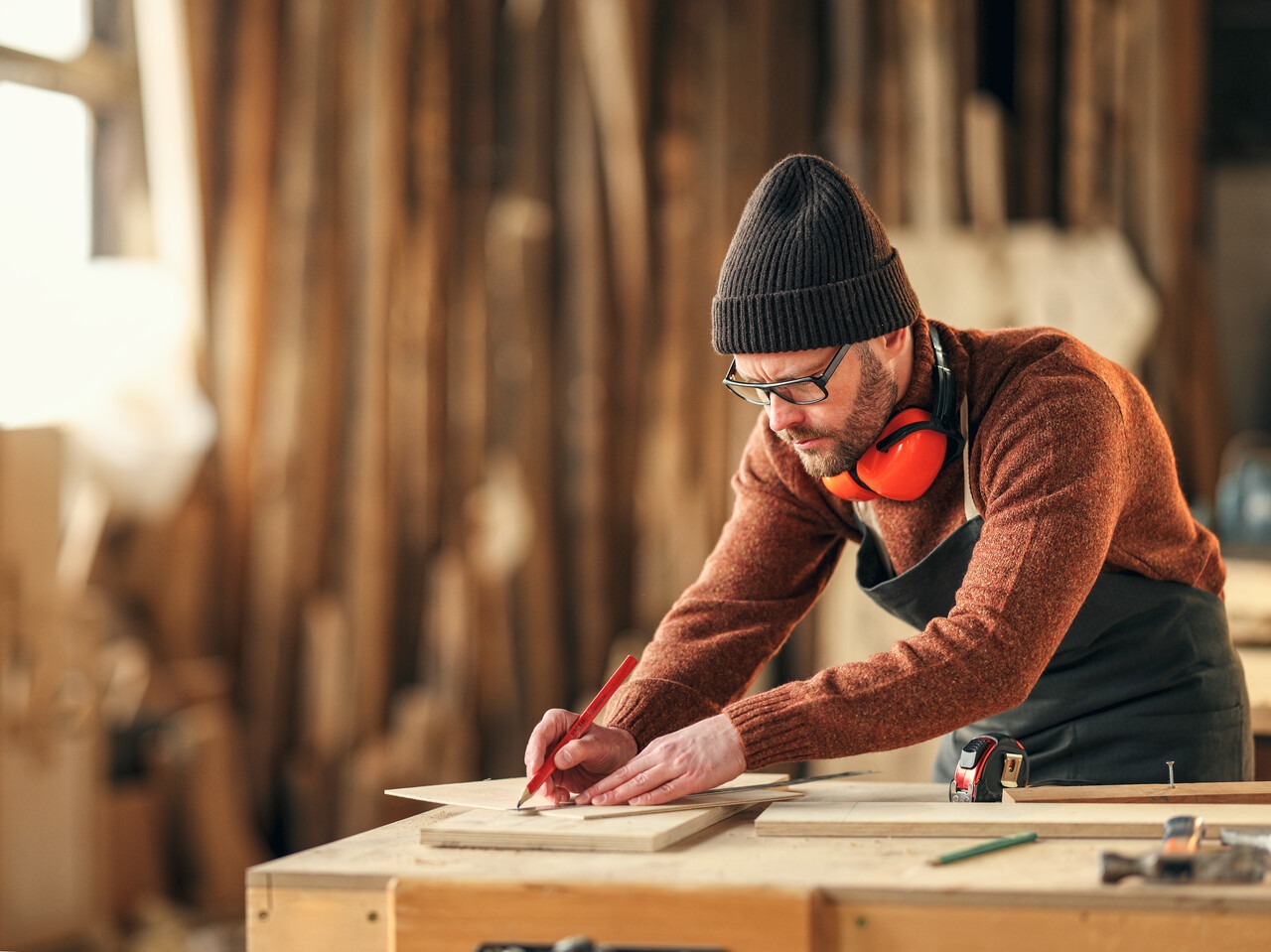 Concentrated,Adult,Woodworker,Marking,Wooden,Piece,With,Pencil,While,Working
